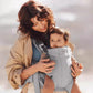 Mother carrying baby in BabyBjörn Carrier One Cotton outdoors – lightweight cotton carrier allows hands-free movement, bonding, and comfort during daily activities.