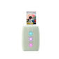 Fujifilm Instax Mini Link 3 in sage green printing a photo with animated hearts. Vertical LED lights glow in blue, purple, and pink. Sleek design with modern texture and instant print output.