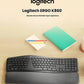  Lifestyle photo of the Logitech ERGO K860 split keyboard placed on a light wooden desk beside notebooks and colored pencils, emphasizing its sleek design and comfortable wrist support.