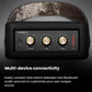 Close-up of the Marshall Stockwell II’s brass control knobs and LED battery indicator, illustrating easy switching between two Bluetooth audio sources.