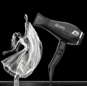 Artistic black and white image of a dancer in flowing dress next to a Parlux Alyon hair dryer, symbolizing powerful airflow and graceful hair movement.