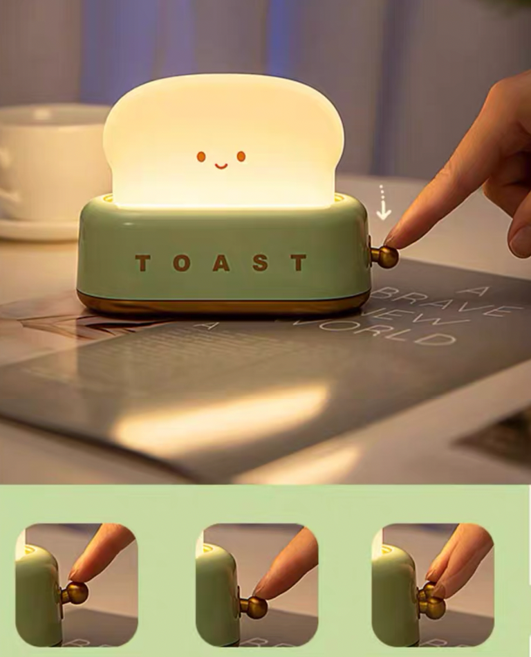 Green toaster night light glowing on dining table beside a vase, plate and softly blurred background