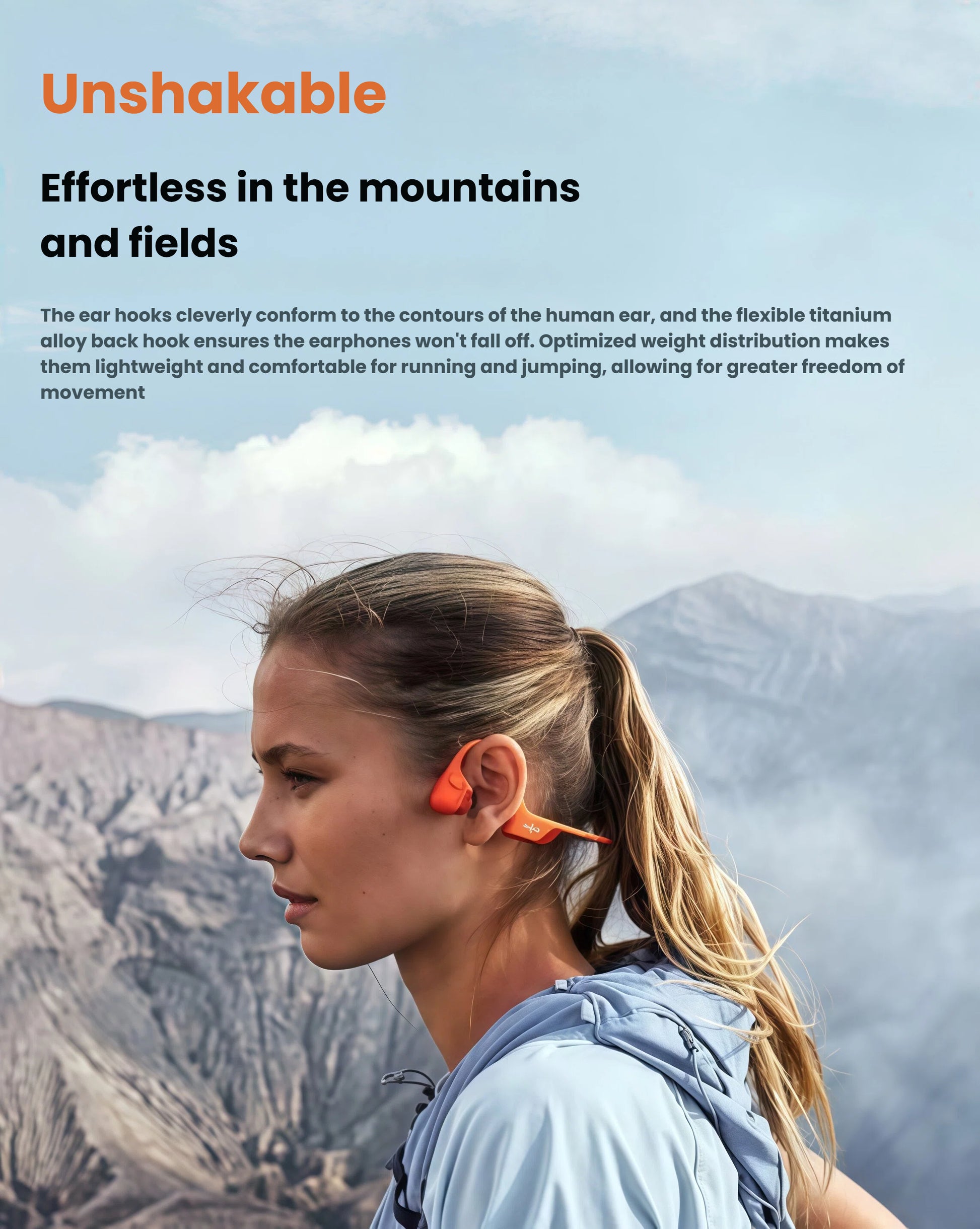 Woman hiking in mountains wearing Shokz OpenRun Pro 2 headphones, demonstrating secure fit with flexible titanium alloy hooks and open-ear design